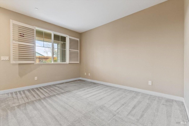 unfurnished room featuring baseboards and carpet