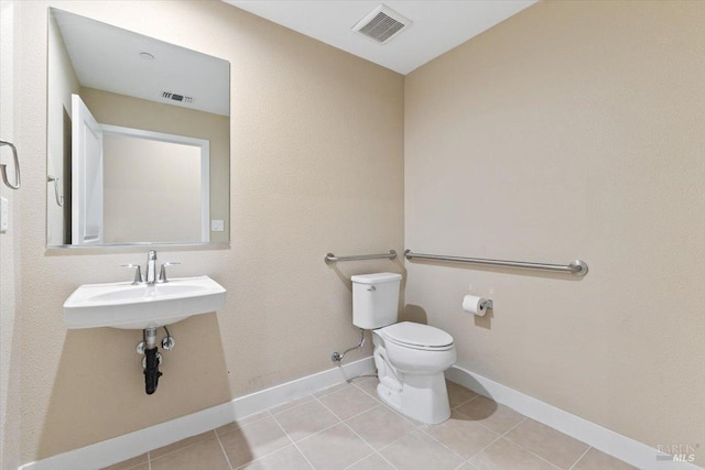 bathroom featuring toilet, tile patterned flooring, visible vents, and baseboards