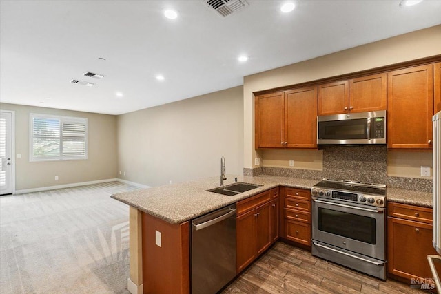 kitchen featuring a sink, visible vents, recessed lighting, brown cabinetry, and appliances with stainless steel finishes