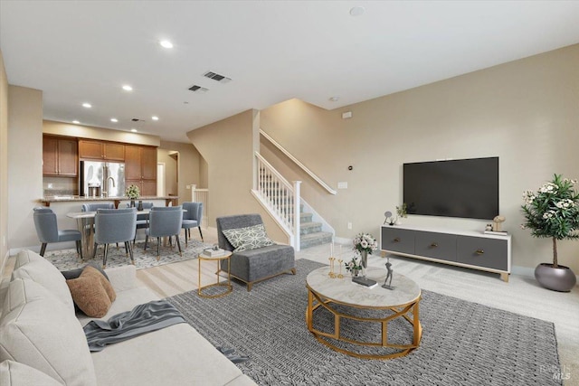 living area featuring stairs, light carpet, baseboards, visible vents, and recessed lighting