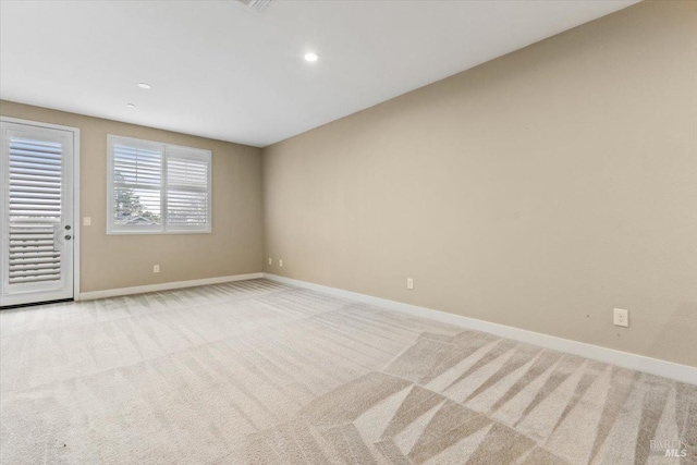 unfurnished room with light colored carpet, baseboards, and recessed lighting