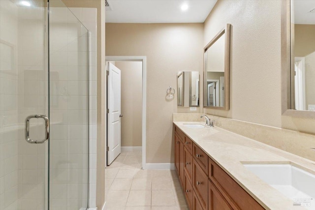 bathroom with tile patterned flooring, a sink, a shower stall, and double vanity