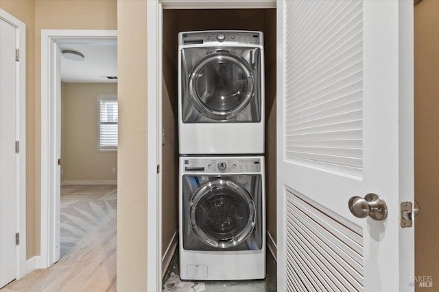 laundry room with stacked washer / drying machine, baseboards, carpet floors, and laundry area