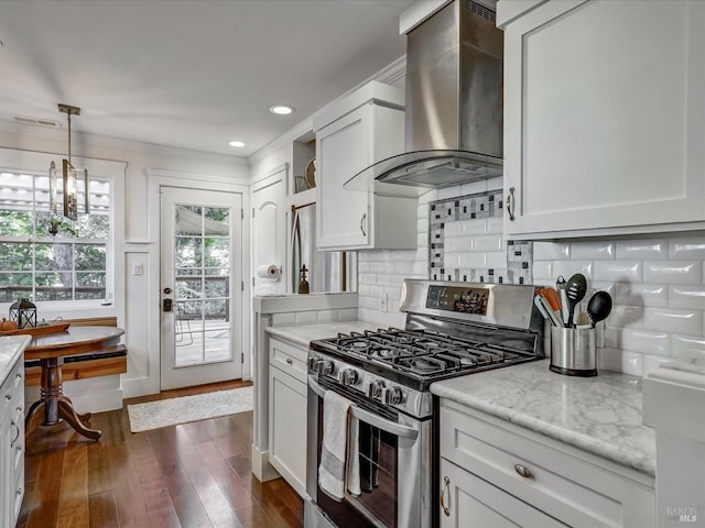 kitchen featuring hanging light fixtures, light stone countertops, ventilation hood, white cabinetry, and gas stove