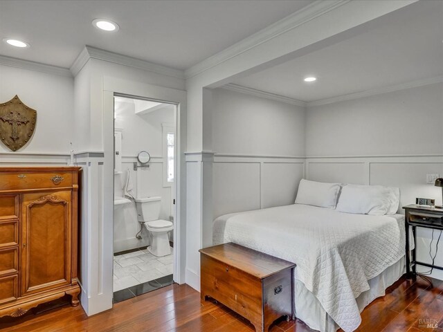 bedroom featuring dark hardwood / wood-style flooring, crown molding, and ensuite bath