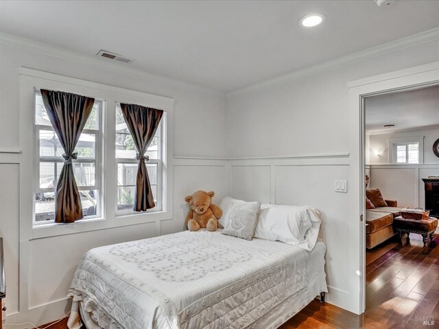 bedroom featuring crown molding and dark hardwood / wood-style floors