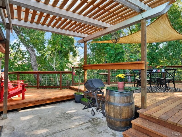 wooden terrace with a grill and a pergola