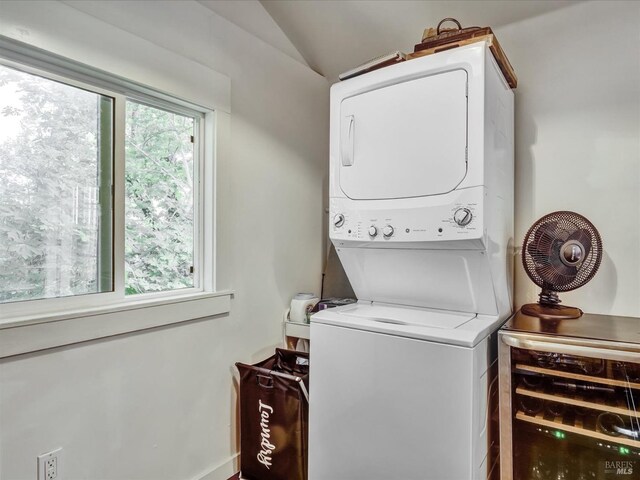 clothes washing area featuring stacked washer and clothes dryer