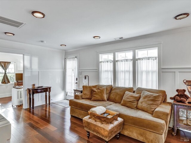 living room featuring dark hardwood / wood-style flooring and crown molding