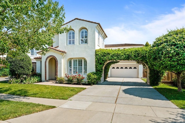 mediterranean / spanish-style house featuring a garage and a front yard