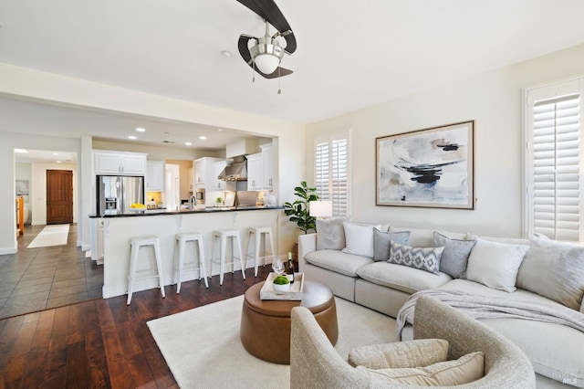 living room with ceiling fan, plenty of natural light, dark hardwood / wood-style floors, and sink