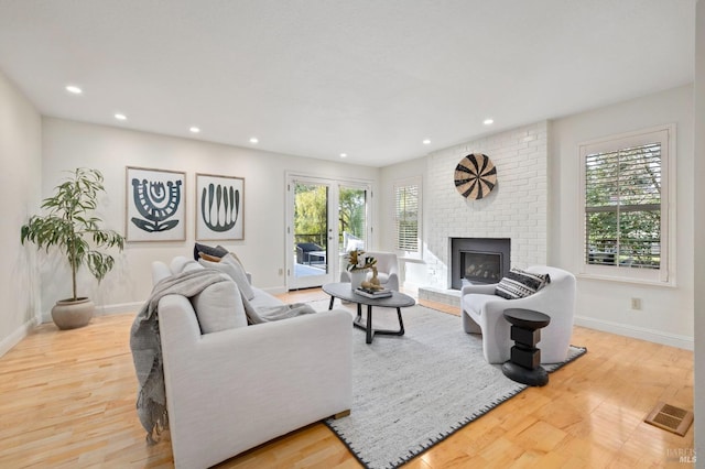 living room with a fireplace and light wood-type flooring