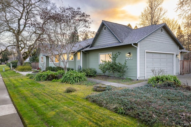 property exterior at dusk with a garage and a yard