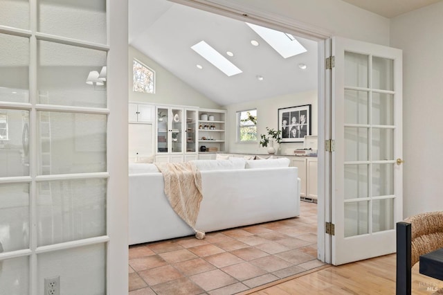 living room with vaulted ceiling with skylight