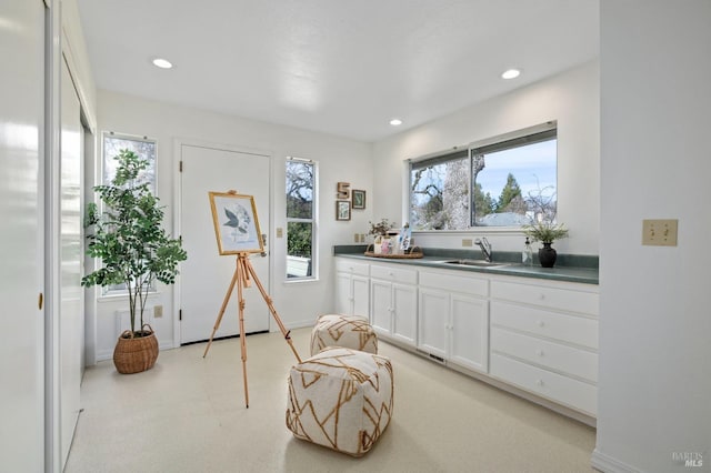 kitchen featuring white cabinetry, sink, and a wealth of natural light