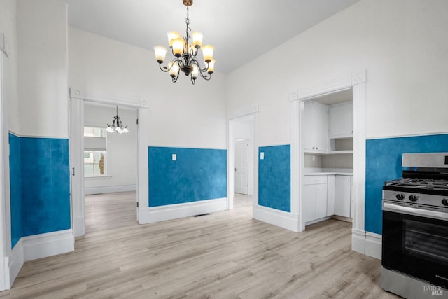 kitchen with gas range, pendant lighting, and an inviting chandelier