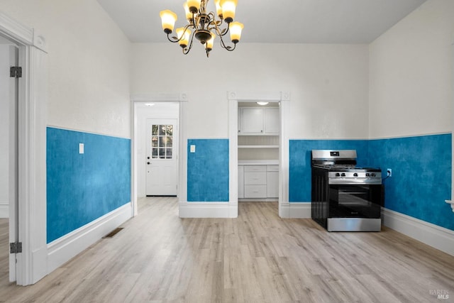 kitchen featuring a chandelier, visible vents, baseboards, light wood finished floors, and gas range