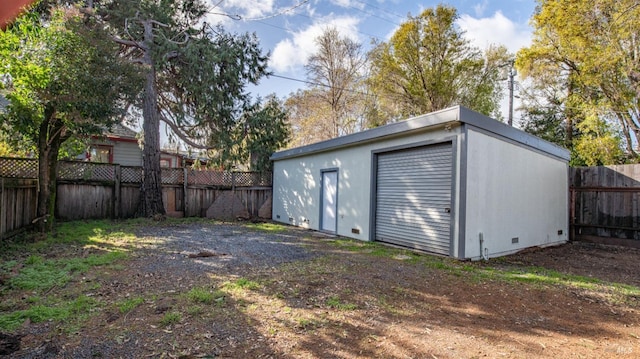 detached garage with fence and dirt driveway