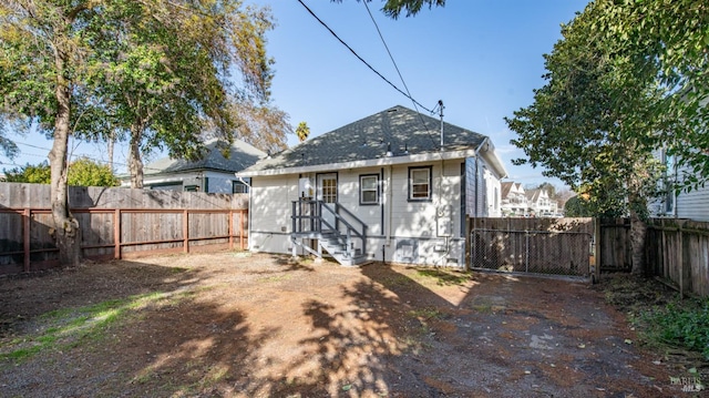 back of property with entry steps and a fenced backyard