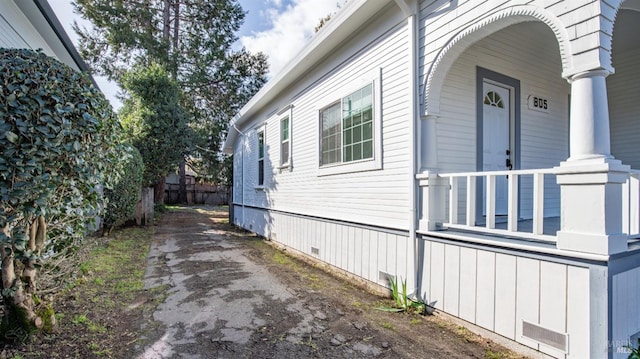 view of side of home featuring a porch and crawl space