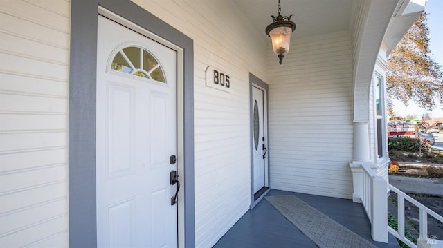 view of exterior entry with covered porch and a garage