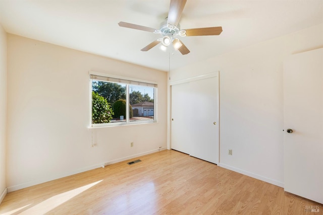 unfurnished bedroom featuring light hardwood / wood-style flooring, a closet, and ceiling fan