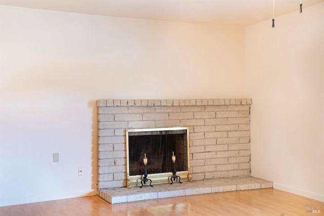 room details featuring a brick fireplace and hardwood / wood-style floors