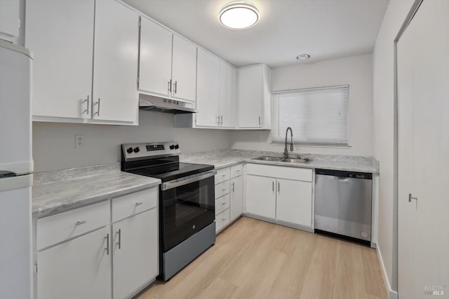 kitchen featuring stainless steel appliances, sink, white cabinets, and light hardwood / wood-style flooring