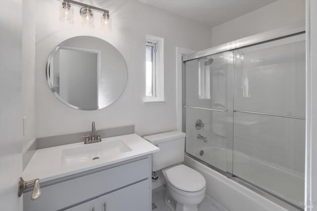 full bathroom featuring toilet, vanity, and bath / shower combo with glass door