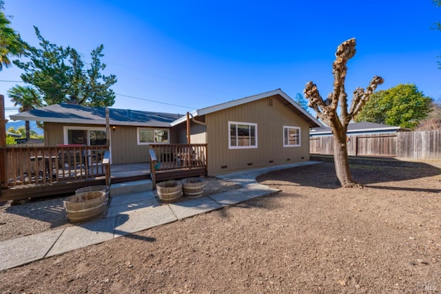 rear view of property featuring a wooden deck