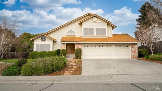 traditional-style house featuring driveway, a tile roof, and fence