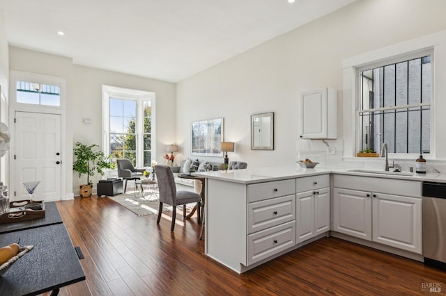 kitchen with dishwasher, white cabinetry, sink, and kitchen peninsula