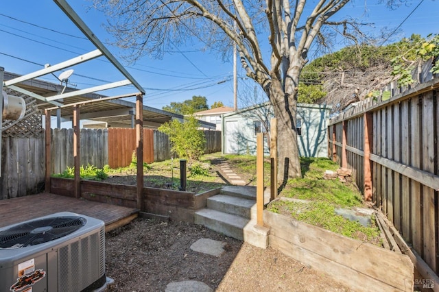 view of yard with cooling unit, a wooden deck, and a storage shed