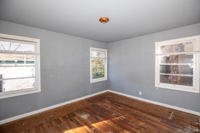 spare room with hardwood / wood-style flooring and a healthy amount of sunlight