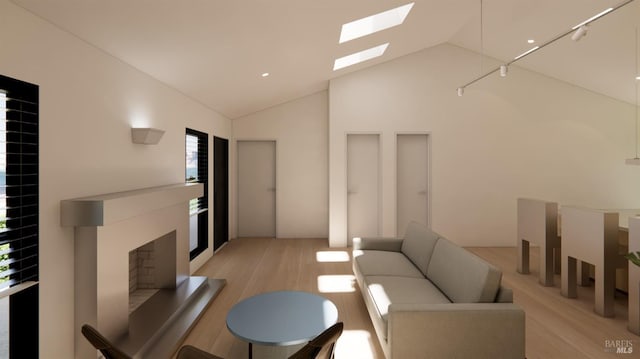 living area with a skylight, a fireplace with raised hearth, high vaulted ceiling, and light wood-style floors