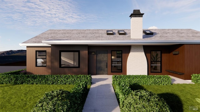 view of front facade featuring brick siding and a chimney