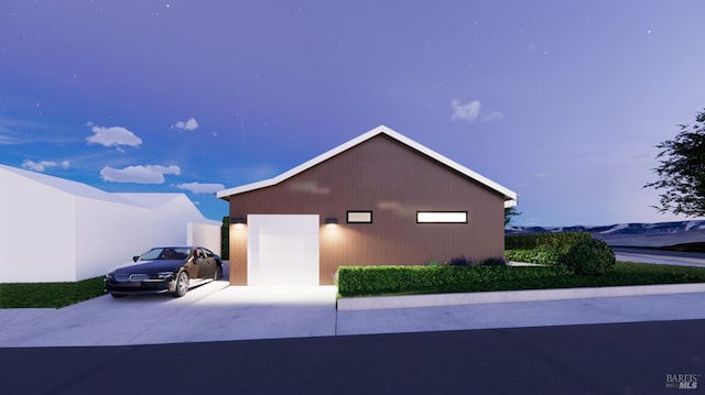 view of home's exterior featuring a detached garage, an outdoor structure, and driveway