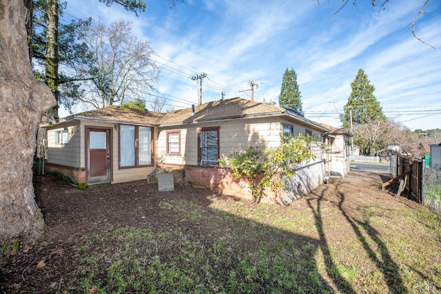 rear view of property featuring a lawn