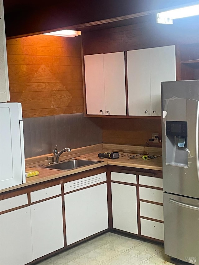 kitchen with white cabinetry, sink, and stainless steel fridge with ice dispenser