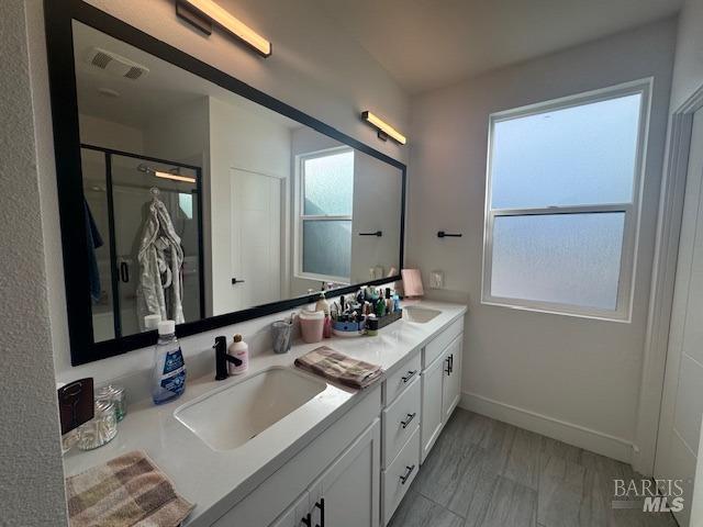 bathroom featuring vanity, wood-type flooring, and a shower with shower door