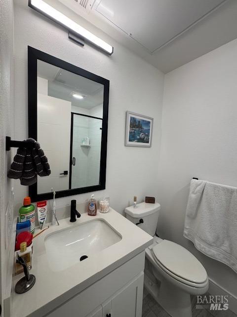 bathroom with vanity, an enclosed shower, and toilet