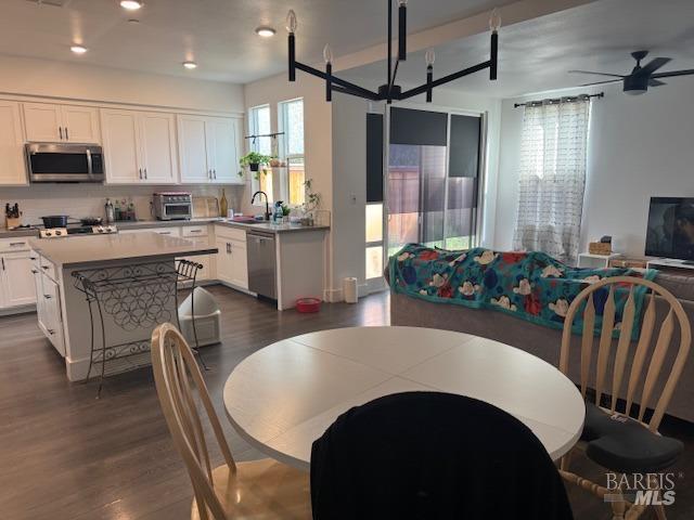 dining space with ceiling fan, dark hardwood / wood-style floors, and sink