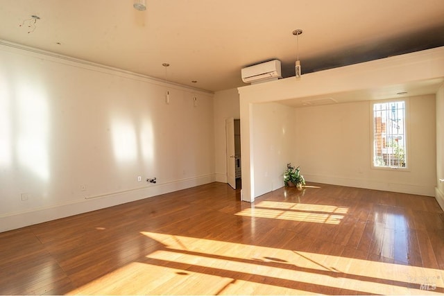 empty room featuring hardwood / wood-style flooring, a wall mounted air conditioner, and crown molding