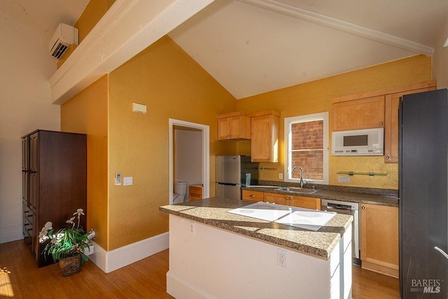 kitchen with a kitchen island, a wall mounted air conditioner, sink, stainless steel appliances, and light wood-type flooring