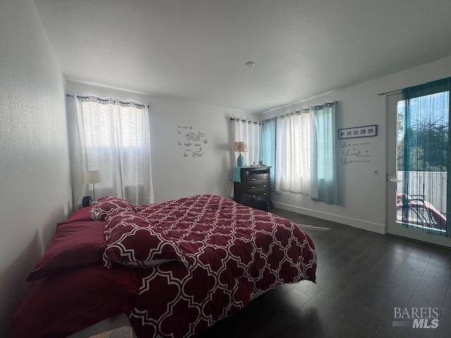 bedroom with access to exterior and hardwood / wood-style floors