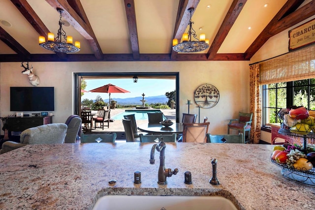 dining room with an inviting chandelier, sink, lofted ceiling with beams, and a healthy amount of sunlight