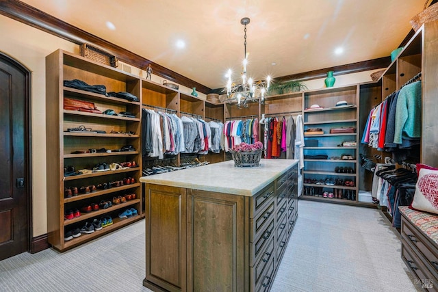 spacious closet with light colored carpet and a notable chandelier