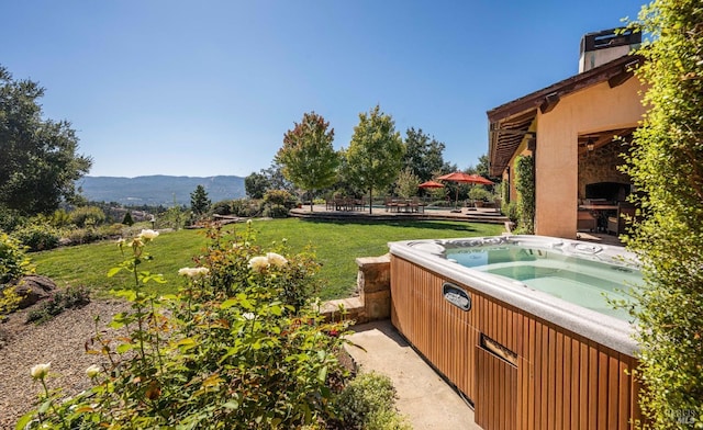 view of yard with a mountain view and a hot tub