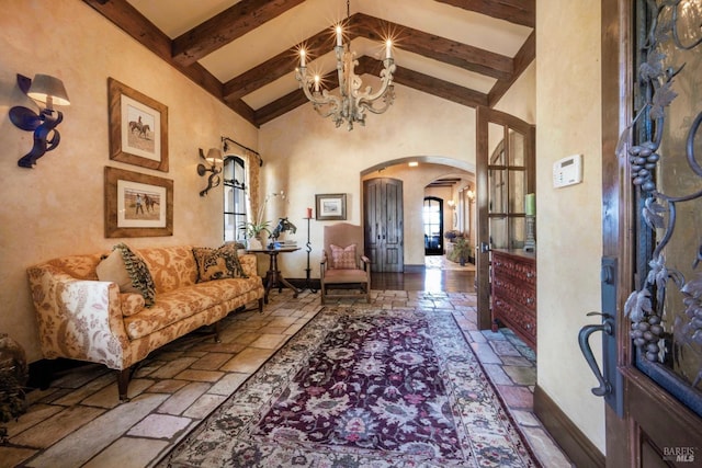 interior space with an inviting chandelier, beam ceiling, and high vaulted ceiling