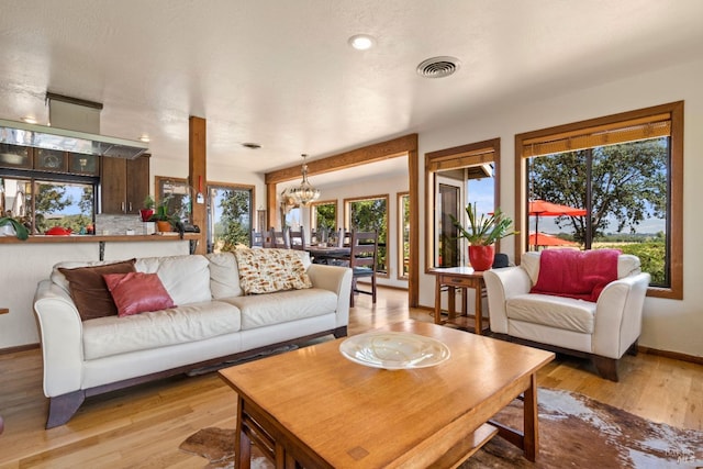 living room with light hardwood / wood-style flooring and a notable chandelier